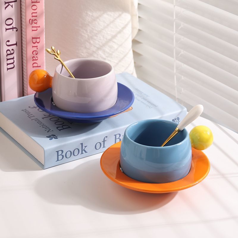 Coffee cups and saucers with contrasting colors and round handles