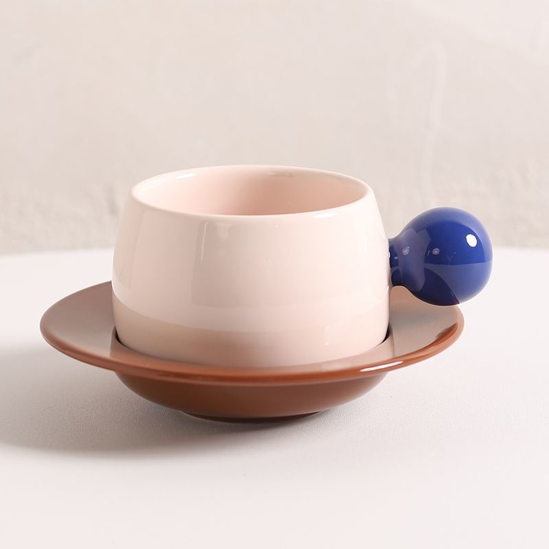 Coffee cups and saucers with contrasting colors and round handles