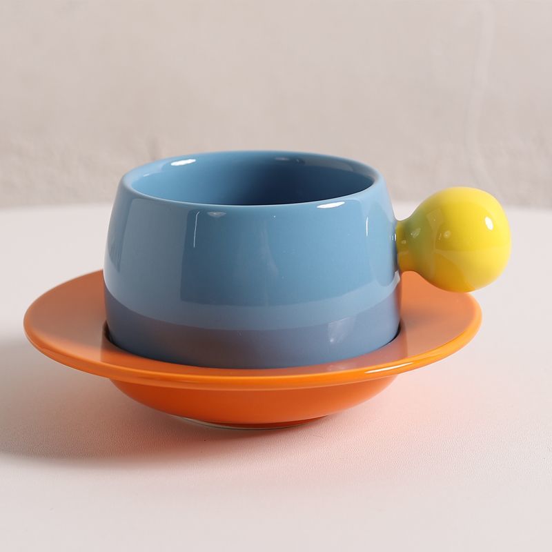 Coffee cups and saucers with contrasting colors and round handles