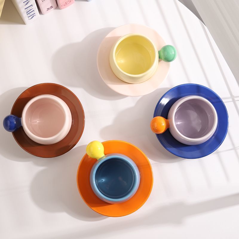 Coffee cups and saucers with contrasting colors and round handles