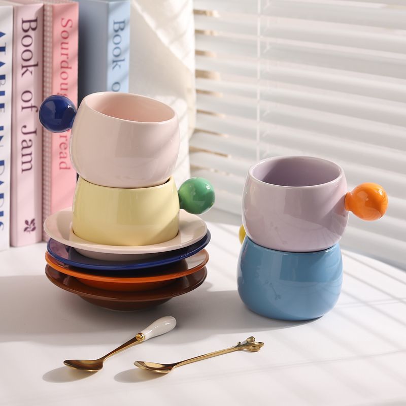Coffee cups and saucers with contrasting colors and round handles