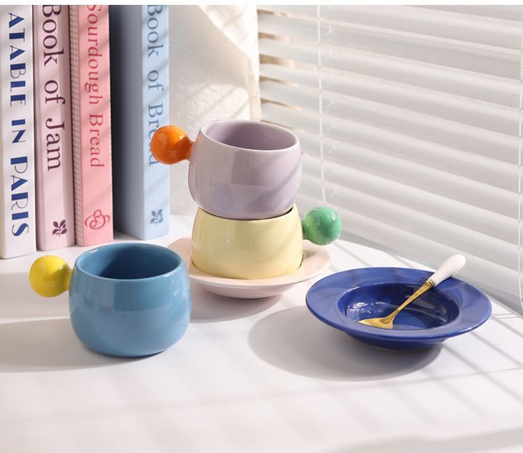 Coffee cups and saucers with contrasting colors and round handles
