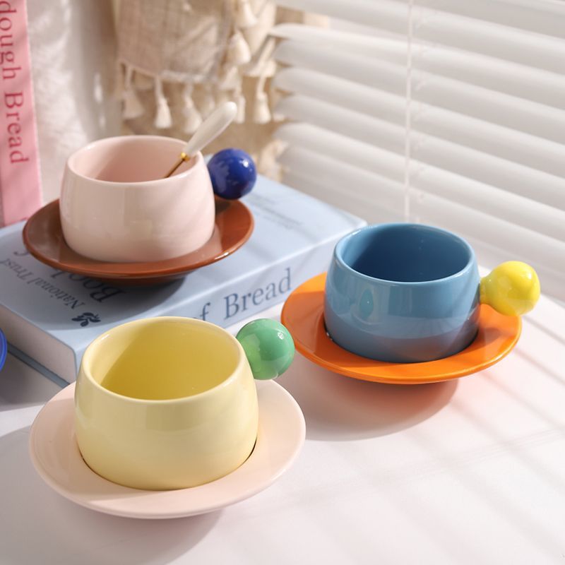 Coffee cups and saucers with contrasting colors and round handles