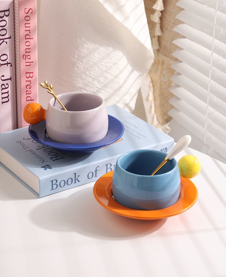 Coffee cups and saucers with contrasting colors and round handles