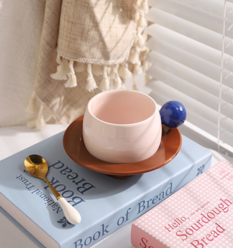 Coffee cups and saucers with contrasting colors and round handles