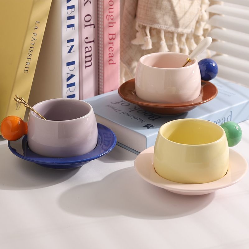 Coffee cups and saucers with contrasting colors and round handles