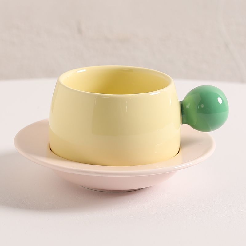 Coffee cups and saucers with contrasting colors and round handles