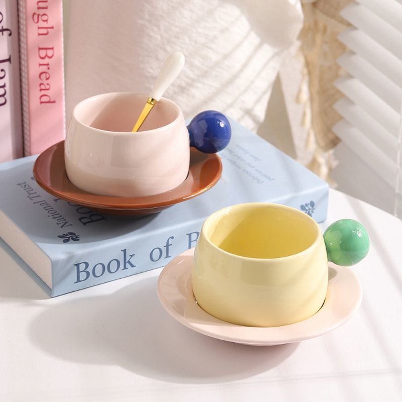 Coffee cups and saucers with contrasting colors and round handles