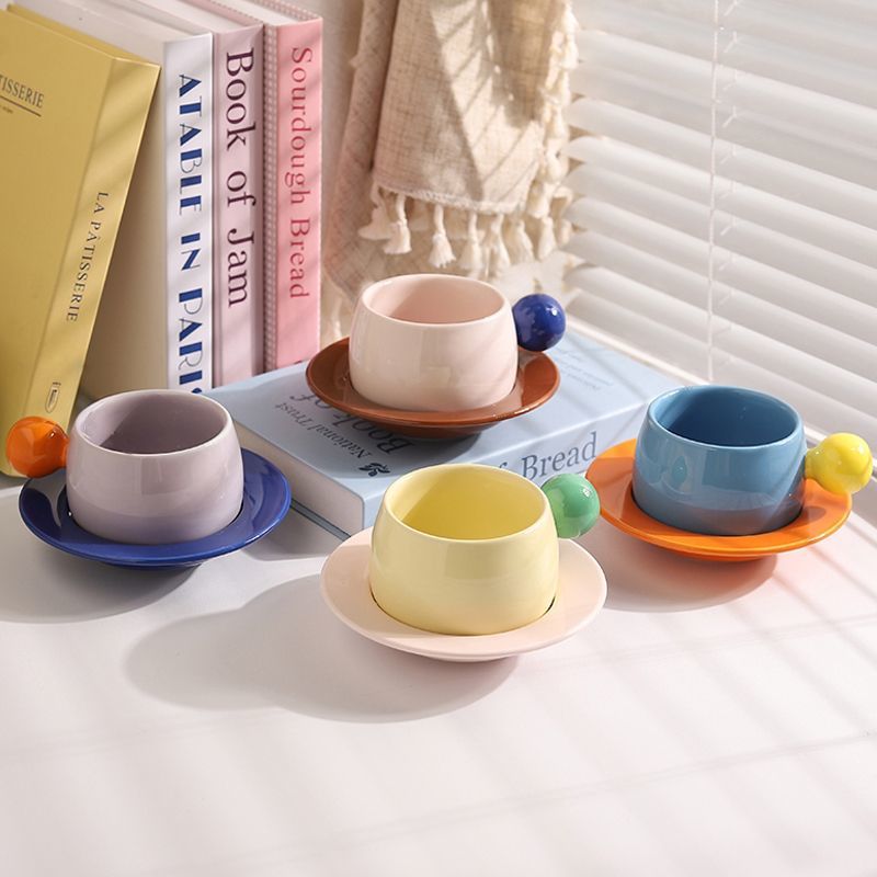 Coffee cups and saucers with contrasting colors and round handles
