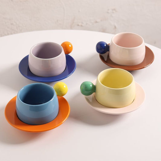Coffee cups and saucers with contrasting colors and round handles