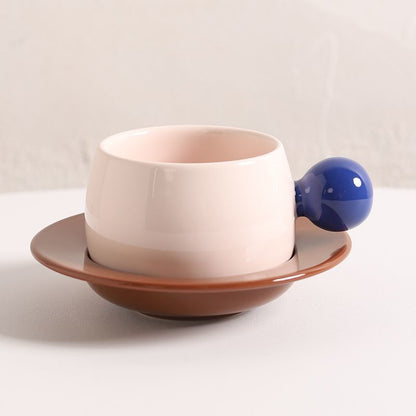 Coffee cups and saucers with contrasting colors and round handles