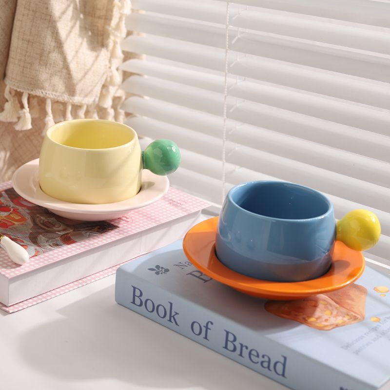 Coffee cups and saucers with contrasting colors and round handles