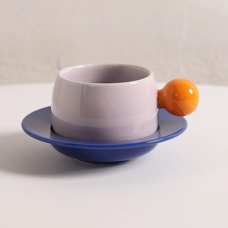 Coffee cups and saucers with contrasting colors and round handles
