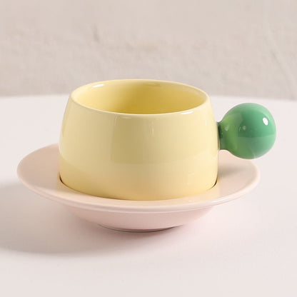 Coffee cups and saucers with contrasting colors and round handles