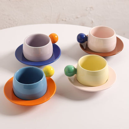Coffee cups and saucers with contrasting colors and round handles
